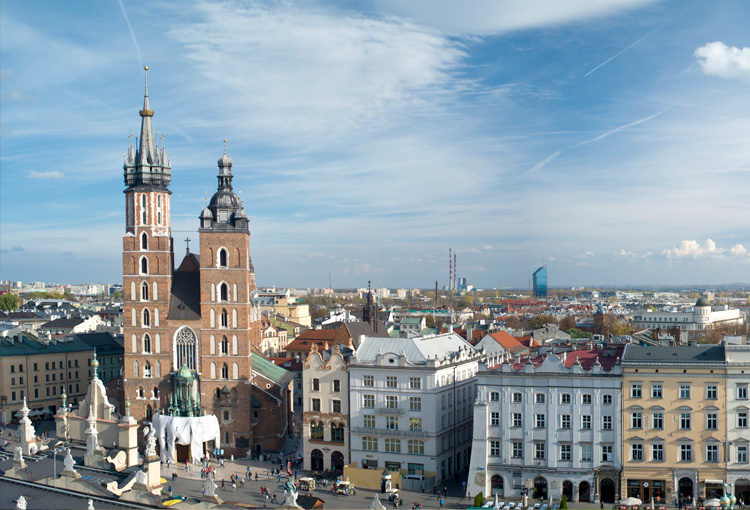 Rynek Główny w Krakowie z widokiem na Kościół Mariacki, zabytkowe kamienice oraz panoramę miasta w słoneczny dzień
